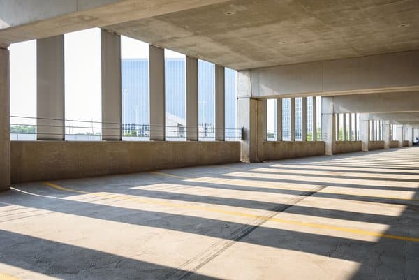 Empty concrete parking garage overlooking office towers, illustrating a failed force majeure clause