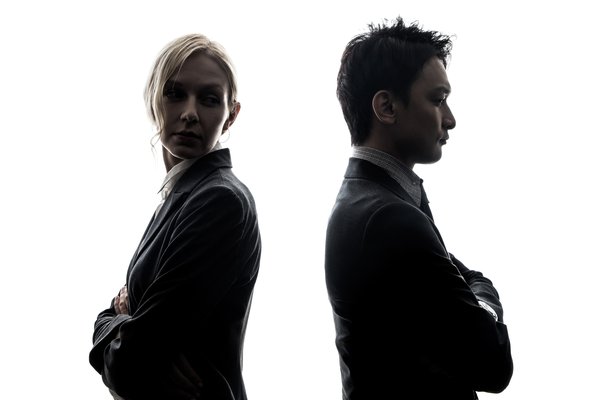 Two business partners standing back to back in silhouette, illustrating shareholder oppression and a competing business