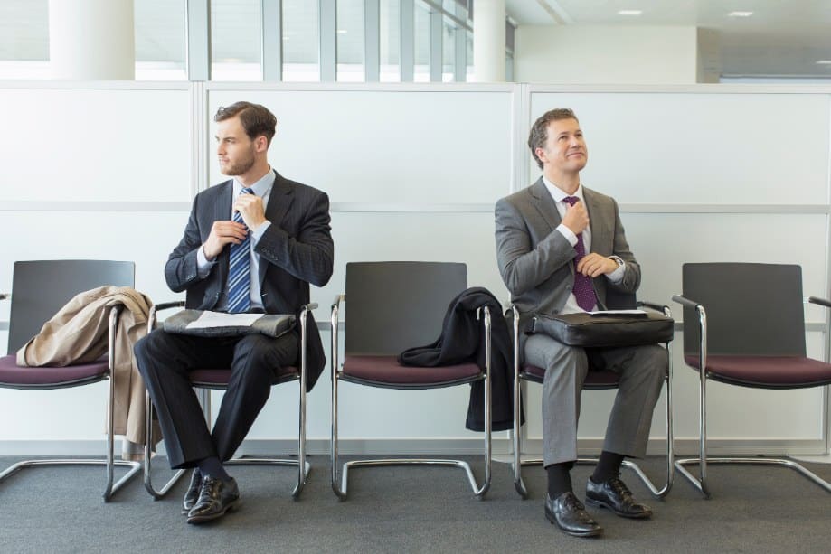two business men in suits ignoring one another